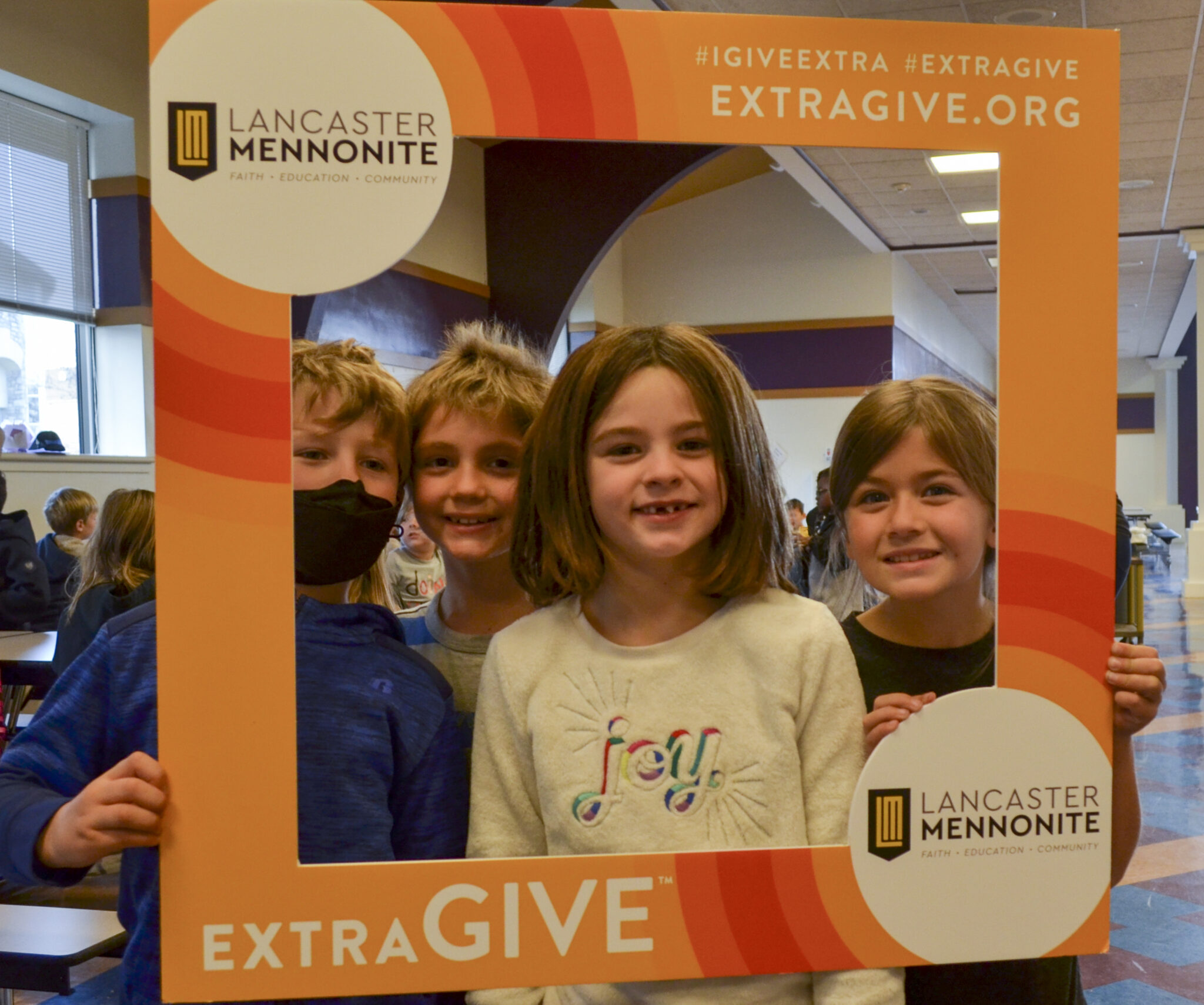 Elementary students at lunch with ExtraGive sign