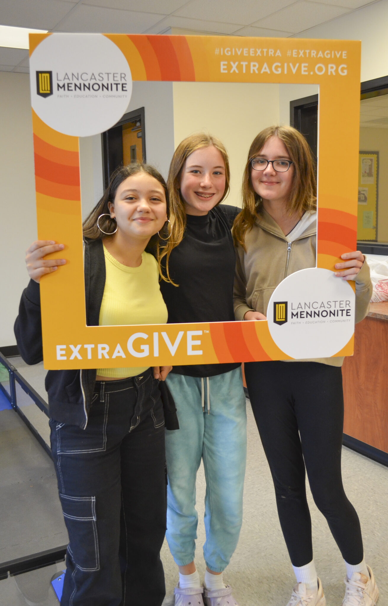 Three LM students holding up Extragive Sign