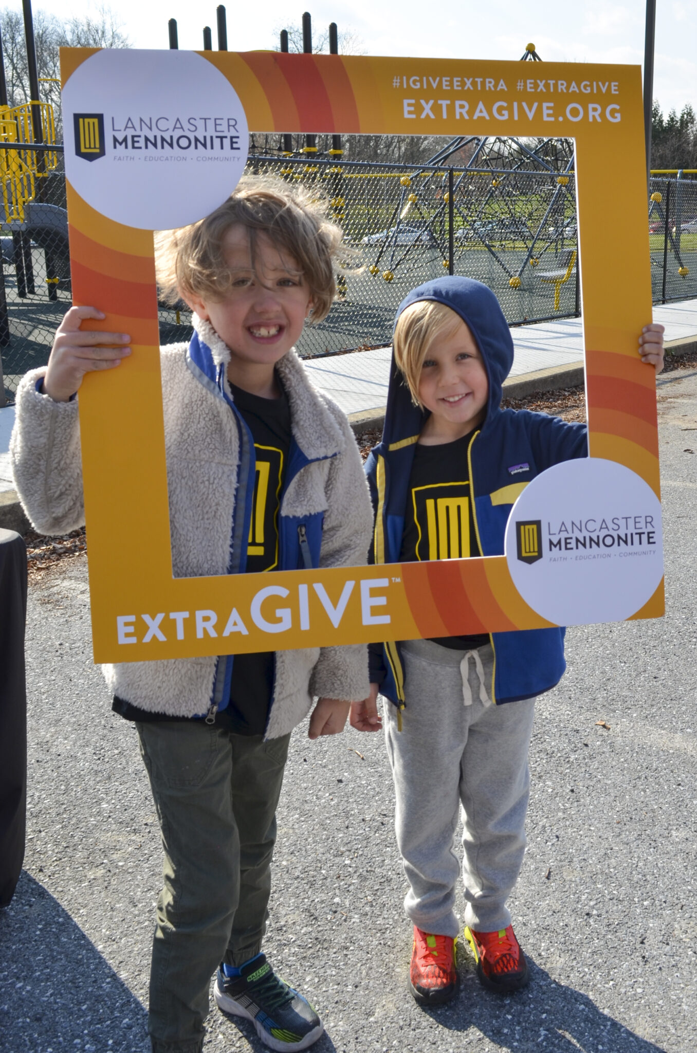 Two LM students holding the Extragive sign.