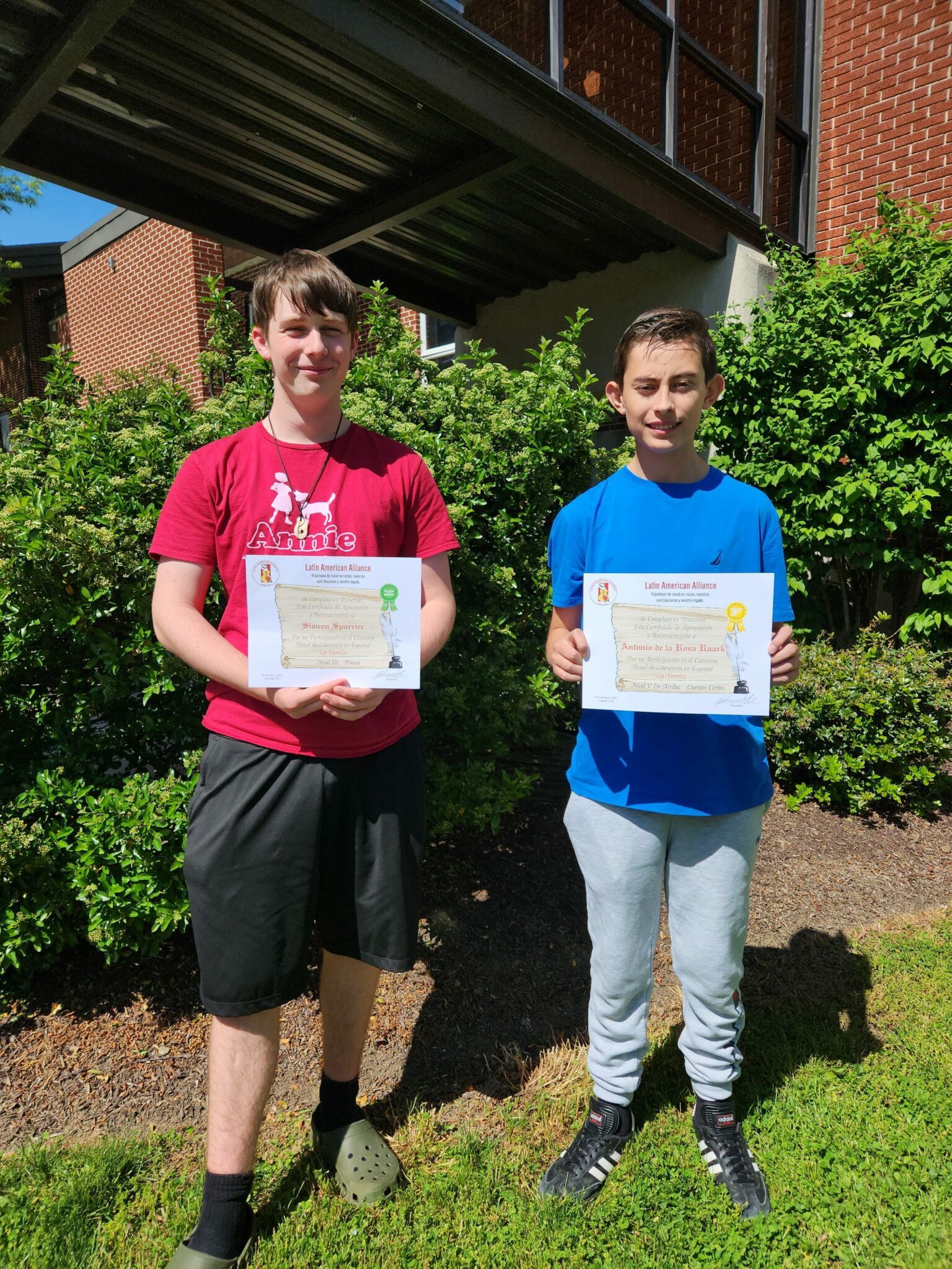 Two students holding their award