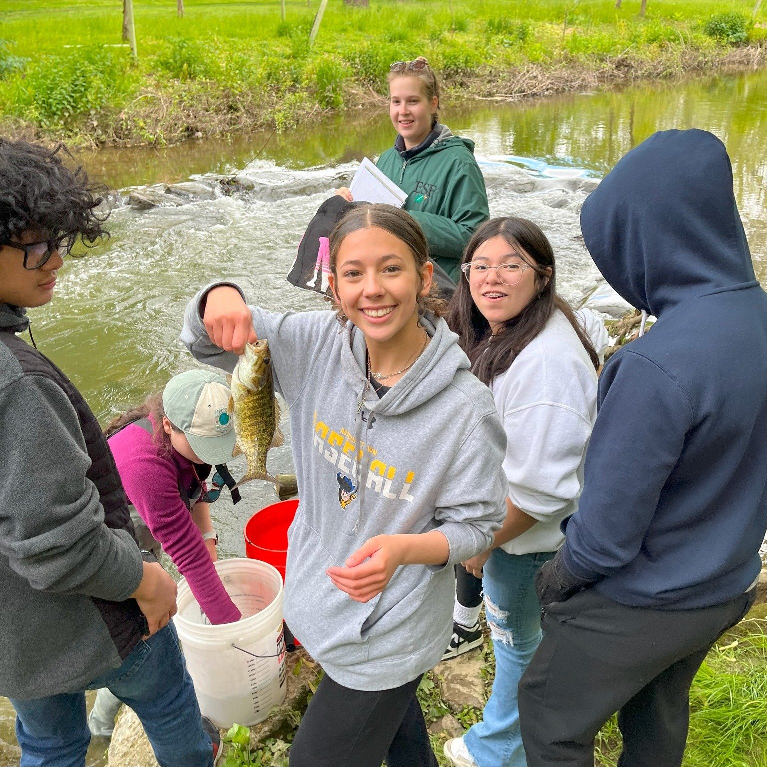 LM students adding fish to the stream