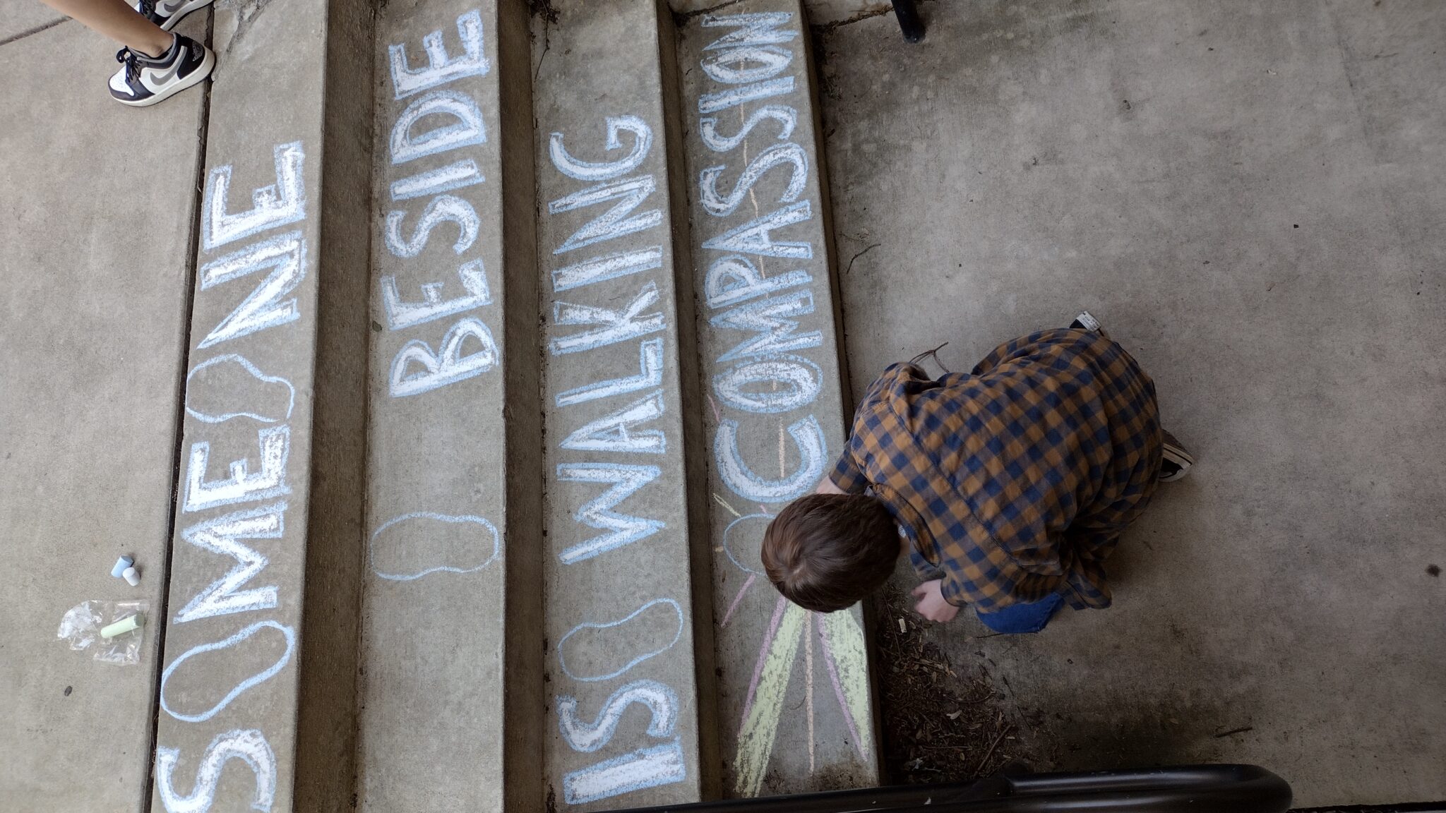 Student drawing on sidewalk