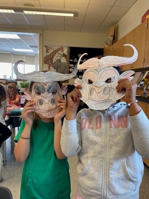 two students showing the masks they made