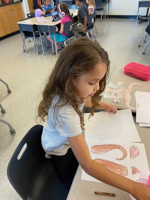 student coloring in her mask