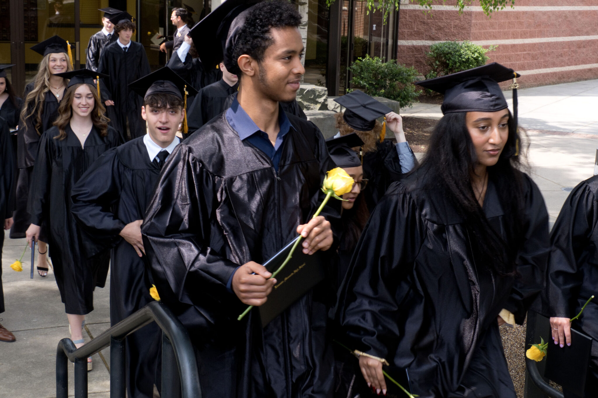 LM students walking out of Fine Arts Center after graduation