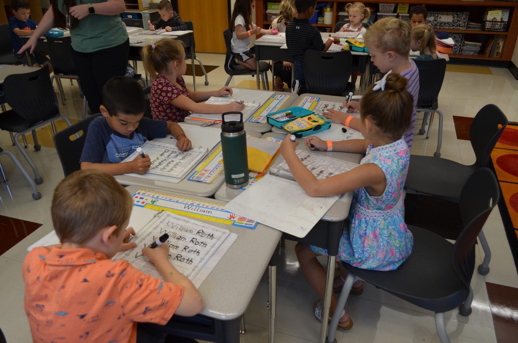 Elementary students practicing writing their name