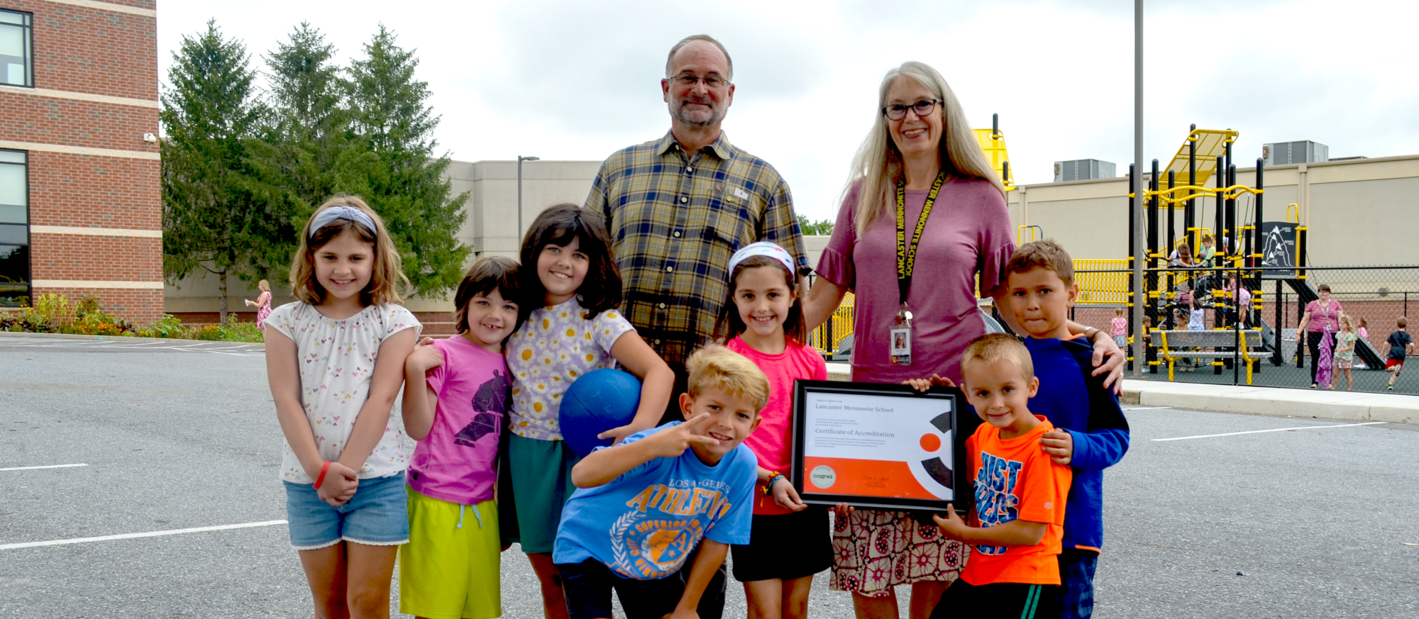 Students and teachers with accreditation certificate.