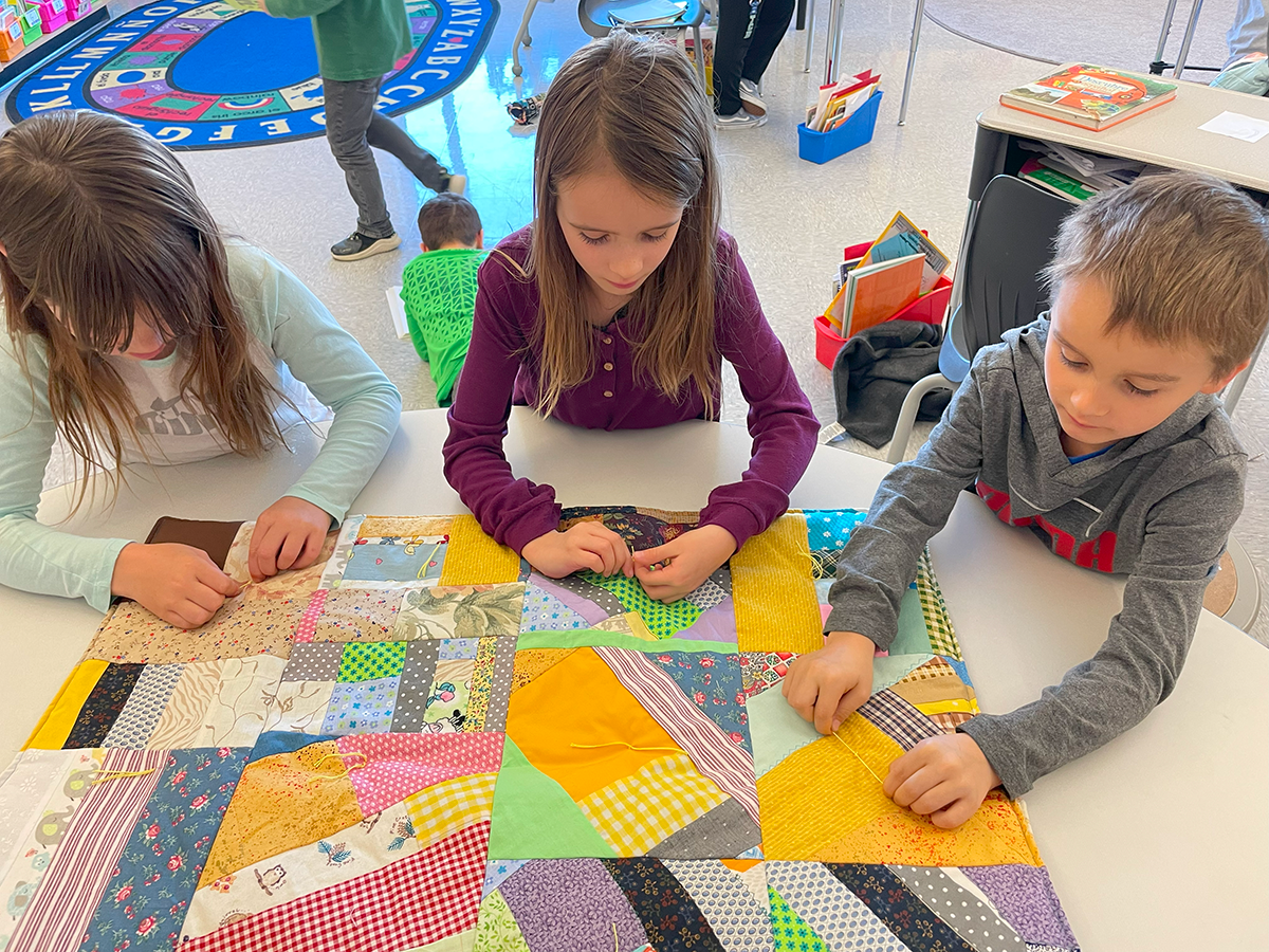 LM students sewing a quilt