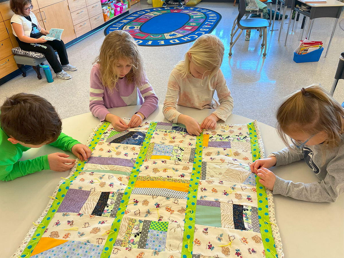 students working on a quilt