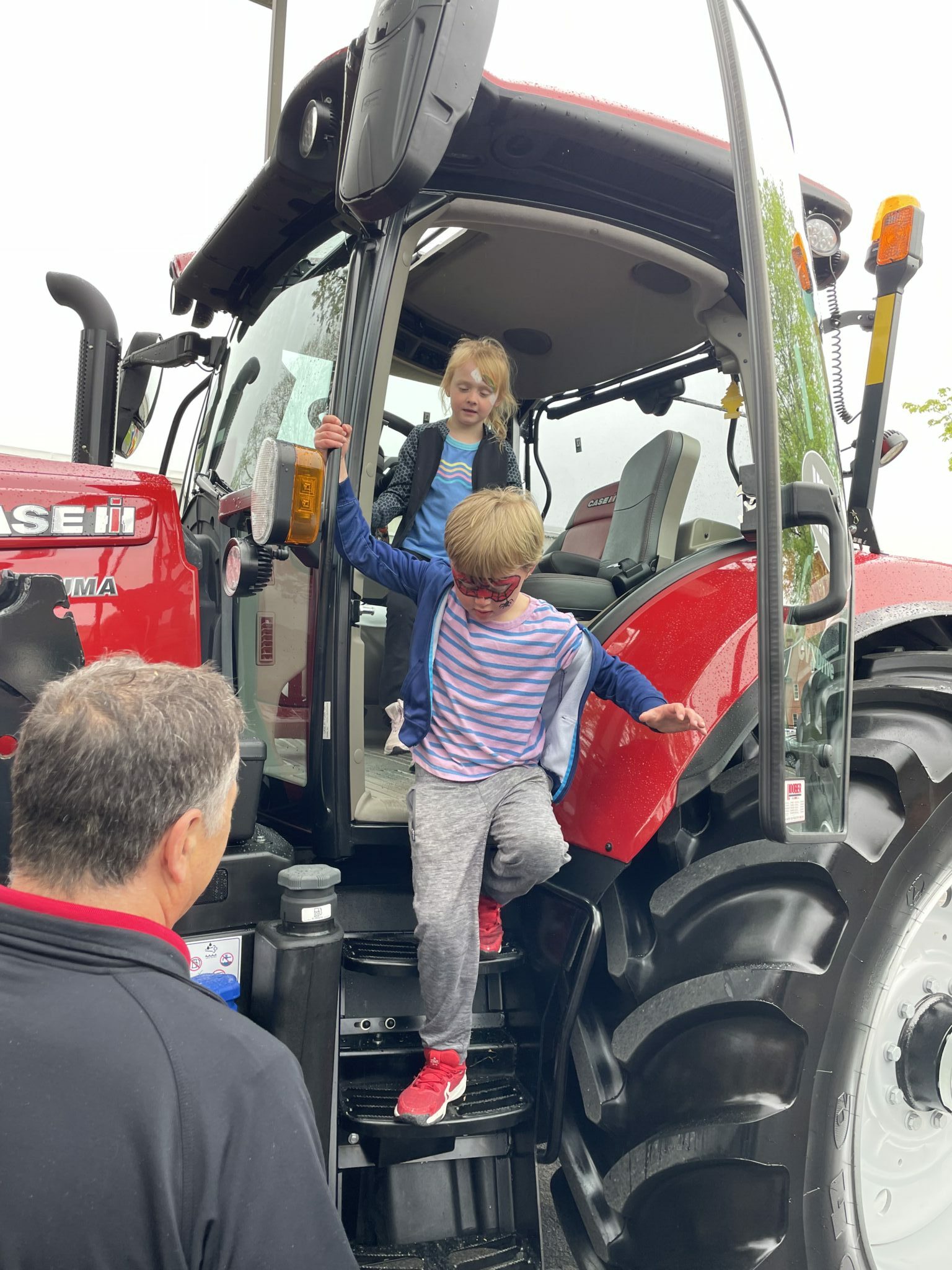 students climbing on tractor