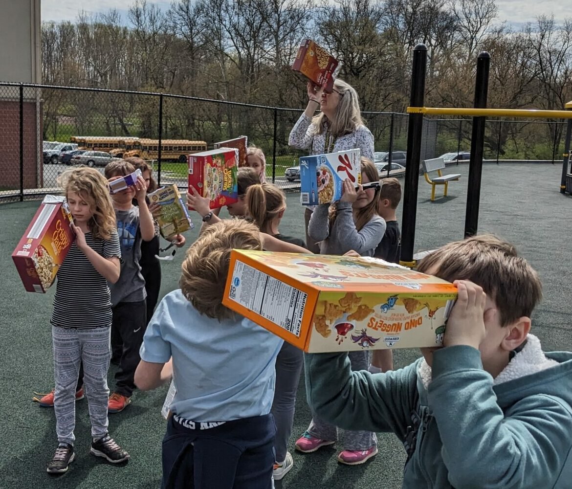 PHOTO: 2ND GRADERS CREATED A PINHOLE SOLAR VIEWER OUT OF CEREAL BOXES FOR AN INCREDIBLE SOLAR ECLIPSE EXPERIENCE. THEY TOOK THEIR BOXES OUTSIDE WHEN THE ECLIPSE STARTED AND HAD TO ADJUST THE ANGLE UNTIL THEY SAW THE SHADOW OF THE SUN SHINE THROUGH THE PINHOLE.