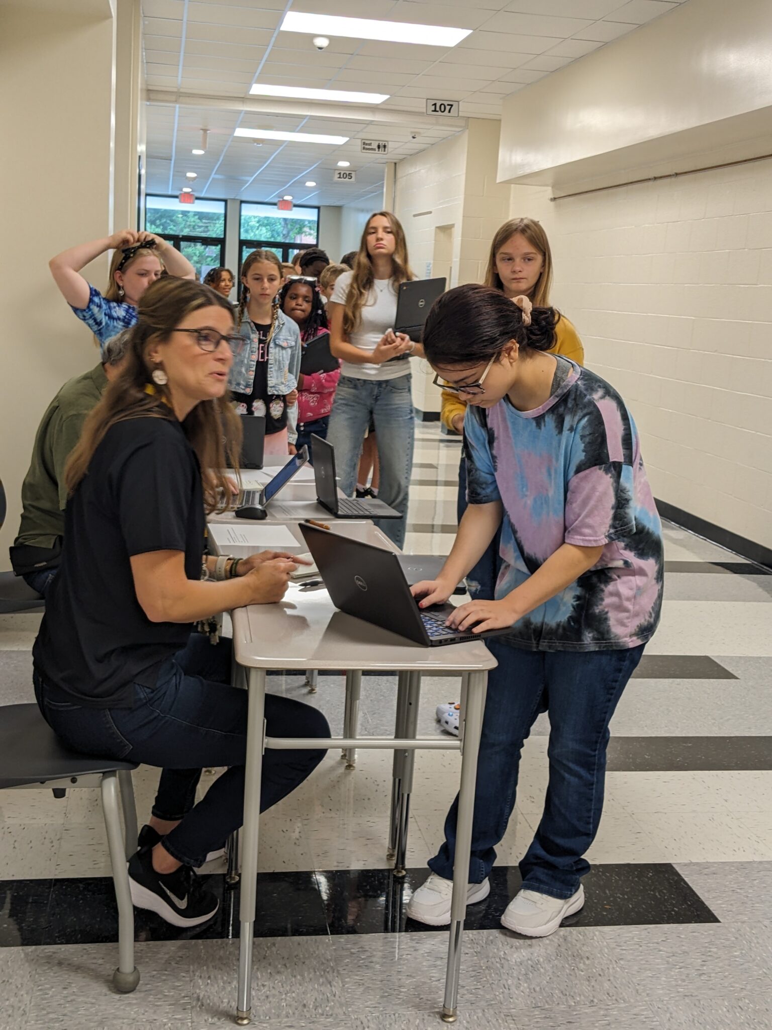 Students with IT staff in hallway