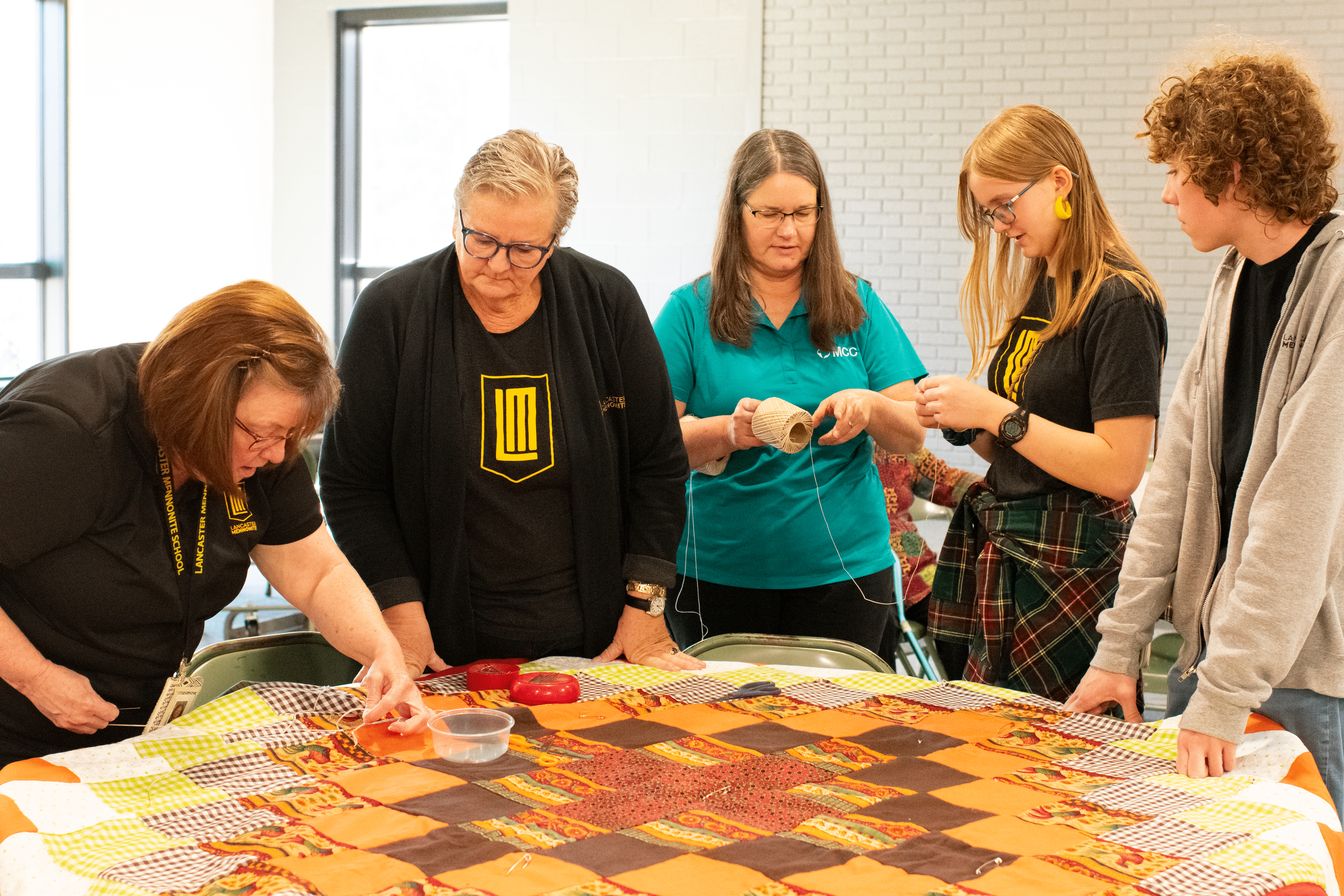 people working on quilt