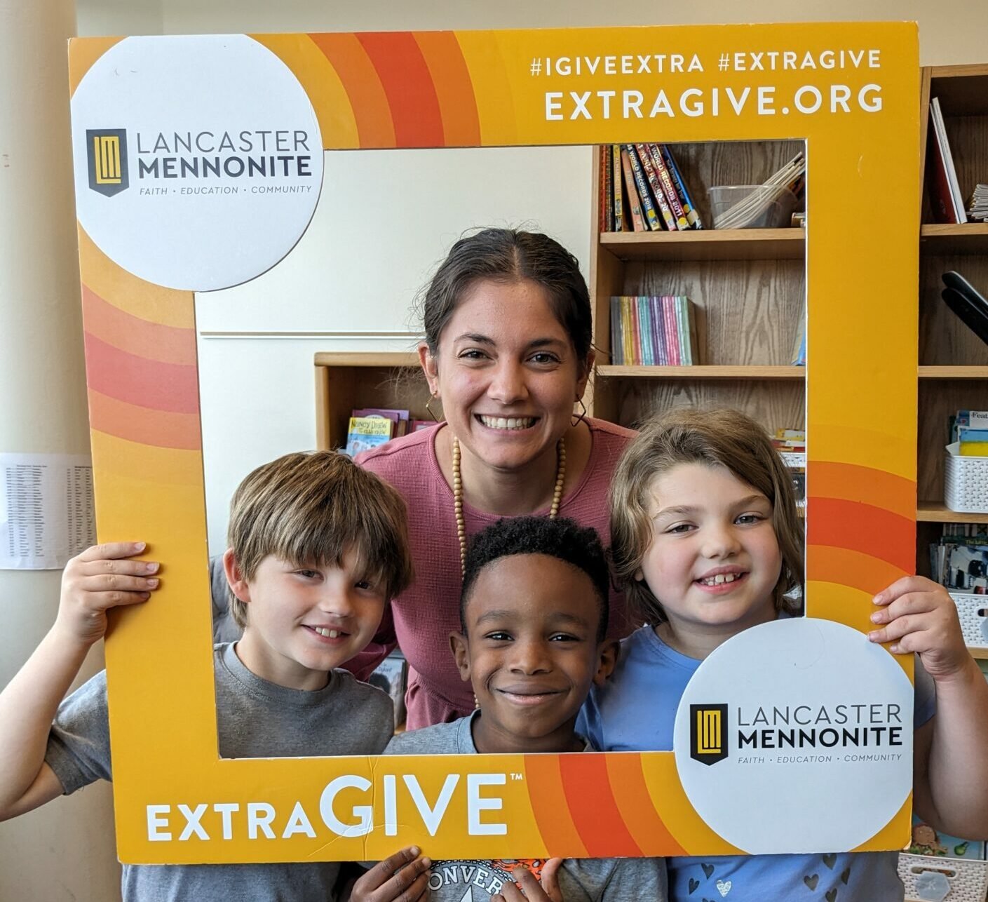 Students and teacher with ExtraGive sign