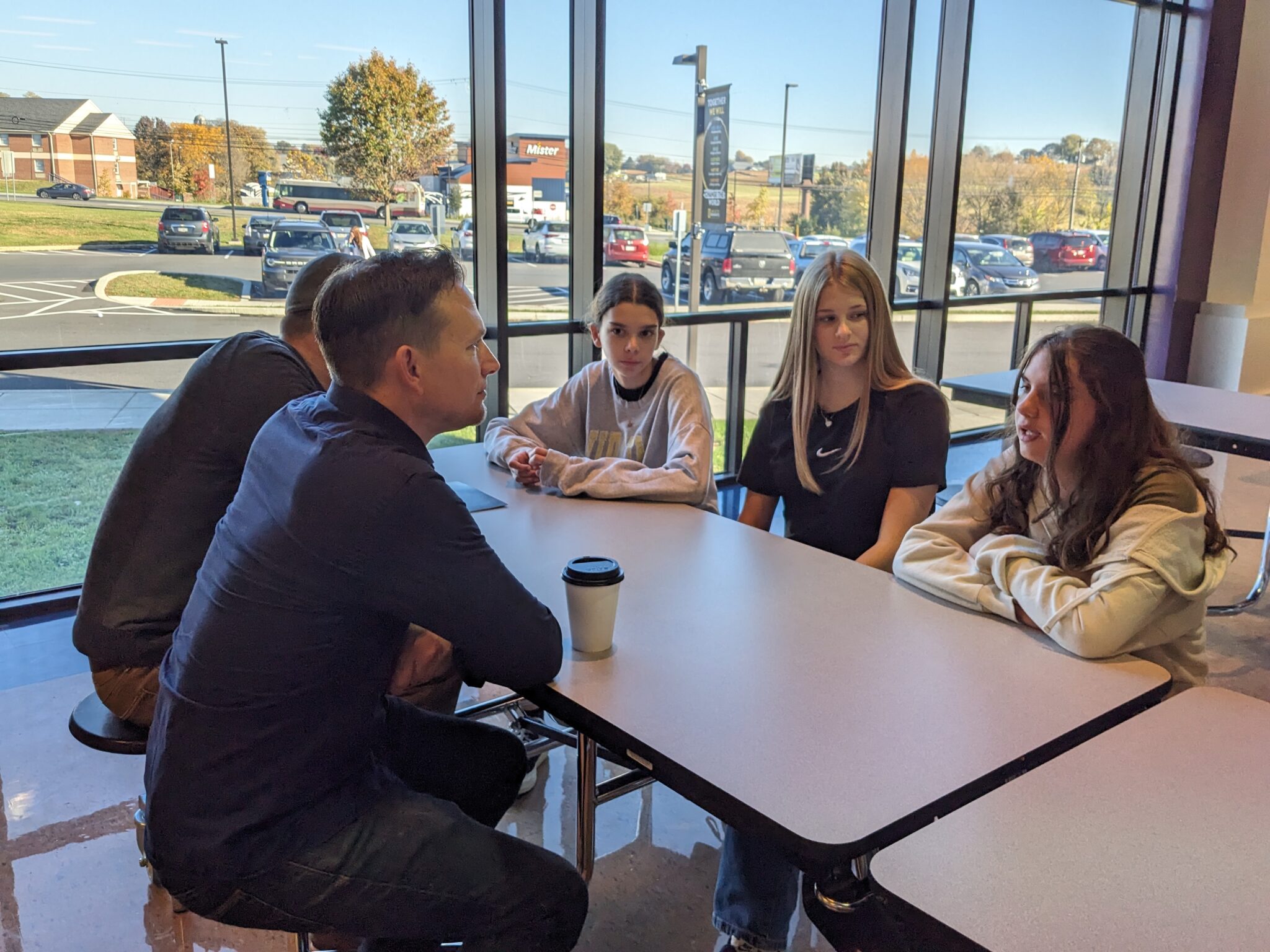 Students with Pastor in cafeteria.