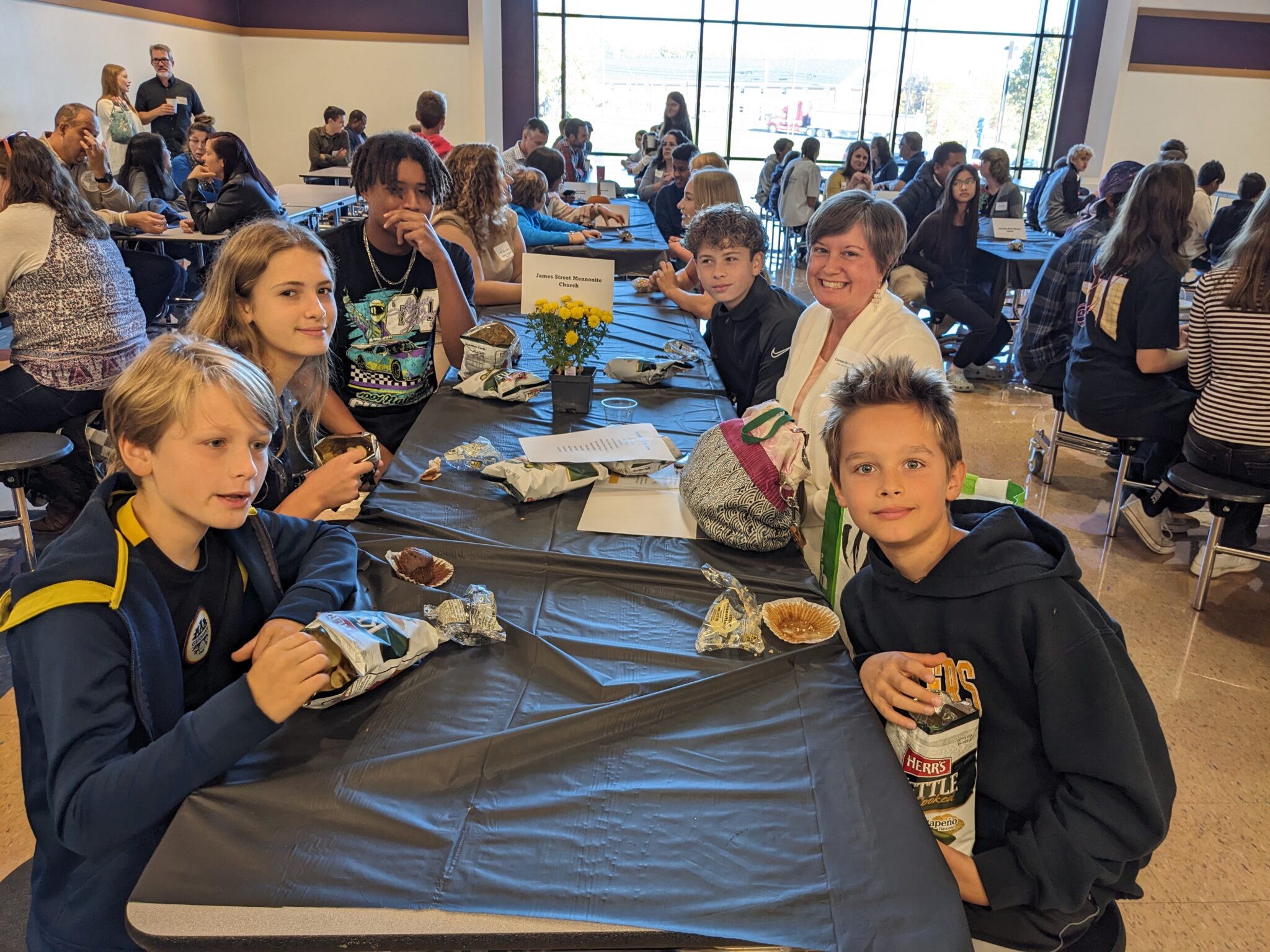 Students with Pastor in cafeteria.