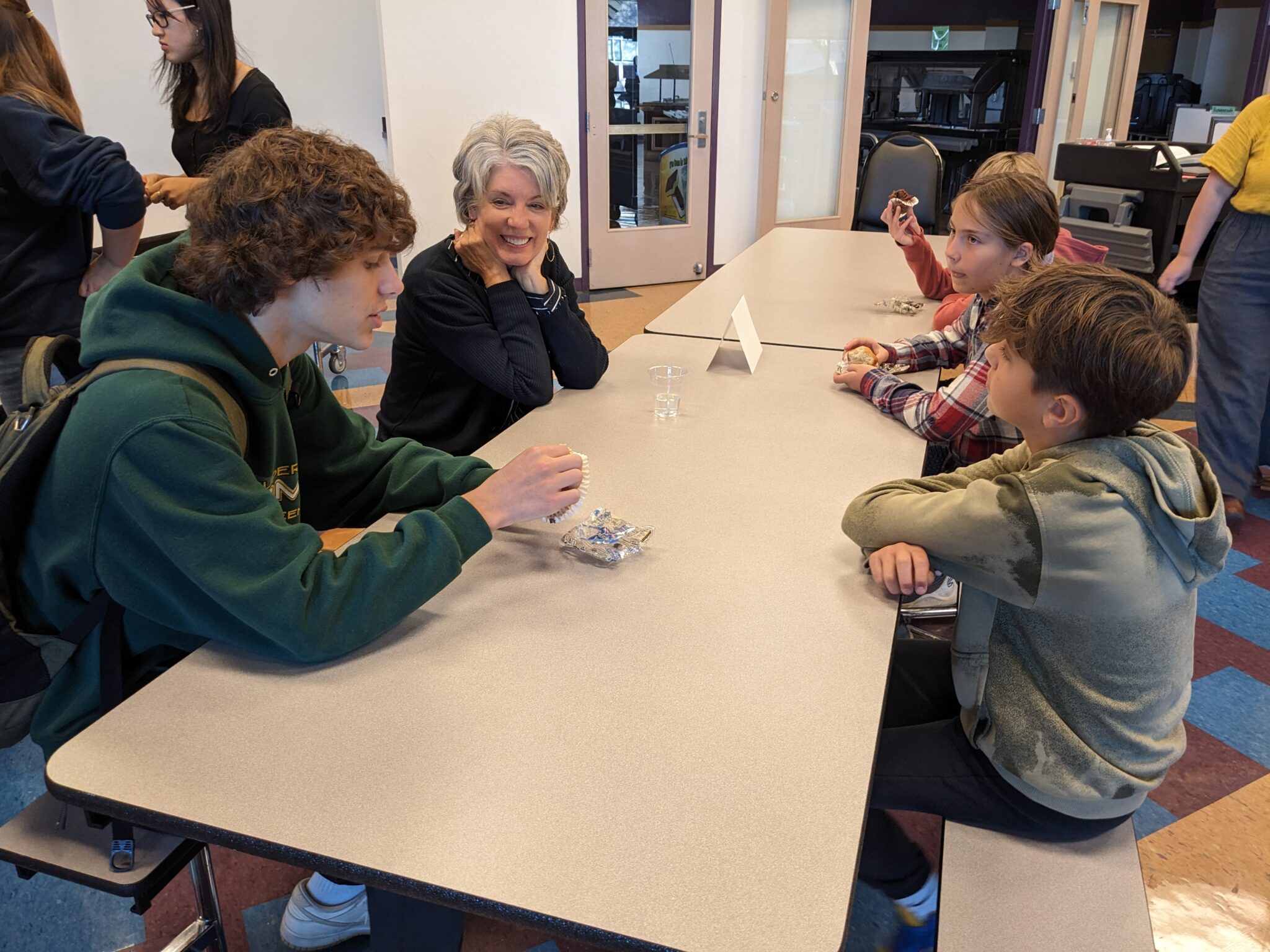 Students with Pastor in cafeteria.