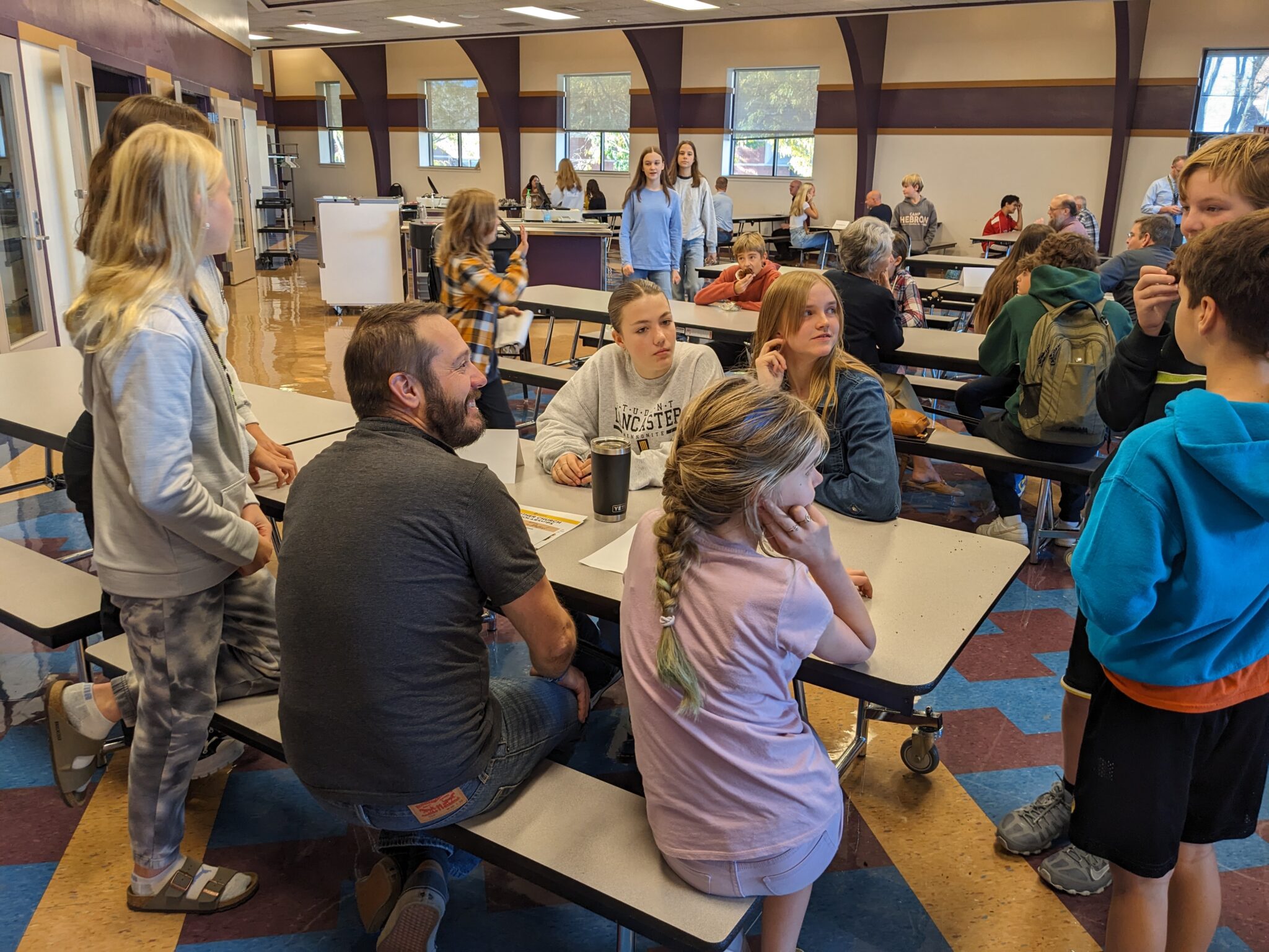 Students with Pastor in cafeteria.