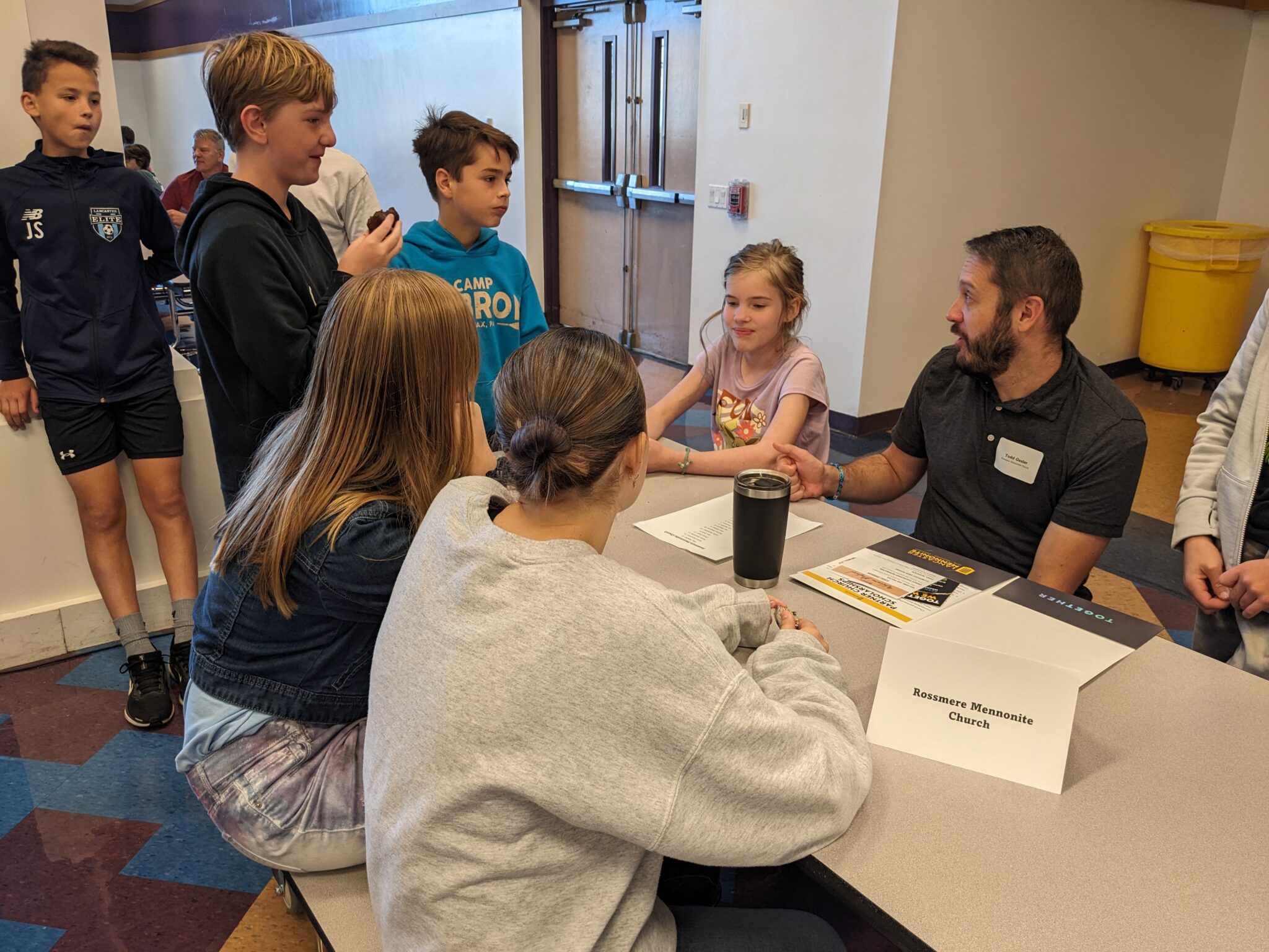 Students with Pastor in cafeteria.