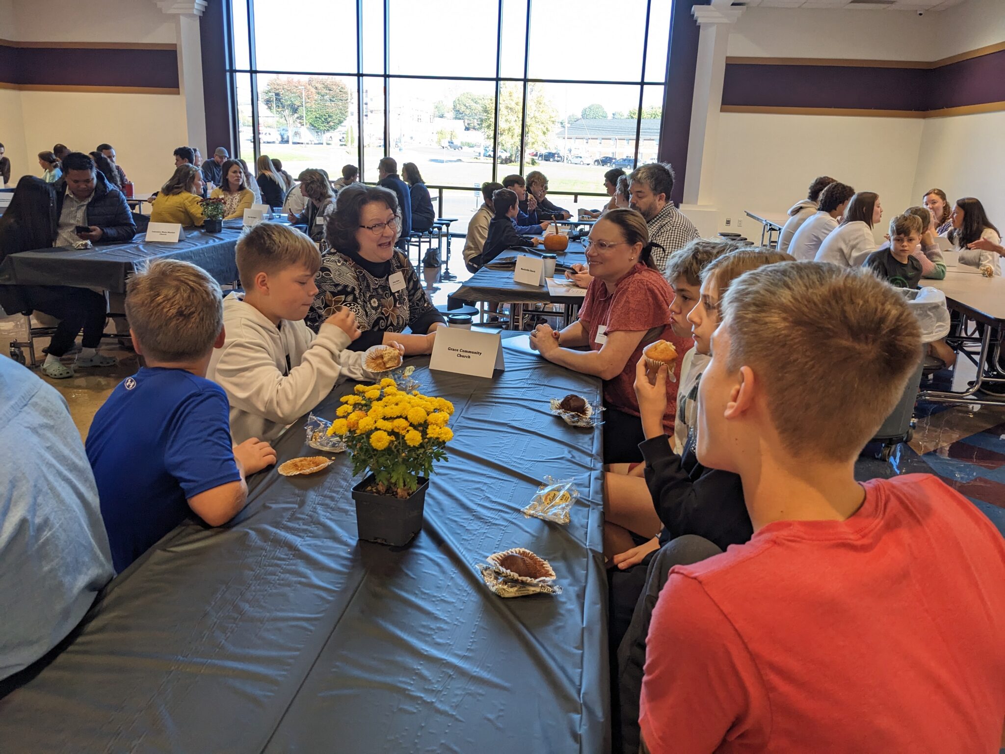 Students with Pastor in cafeteria.