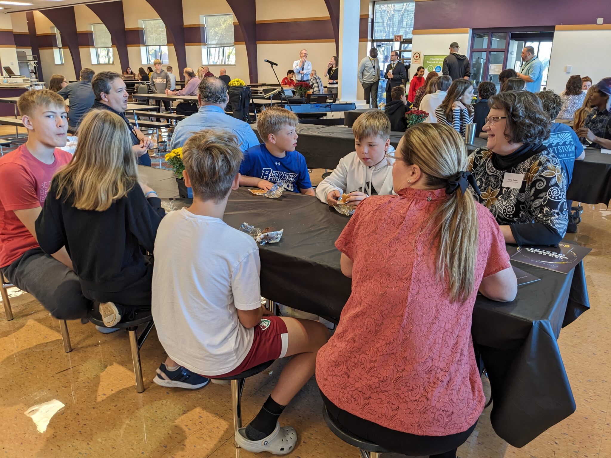 Students with Pastor in cafeteria.