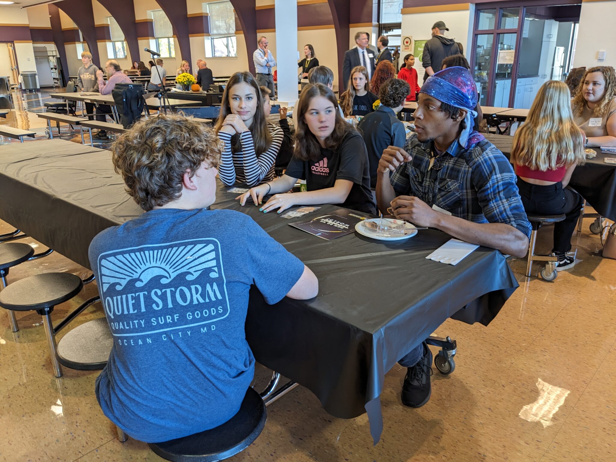 Students with Pastor in cafeteria.