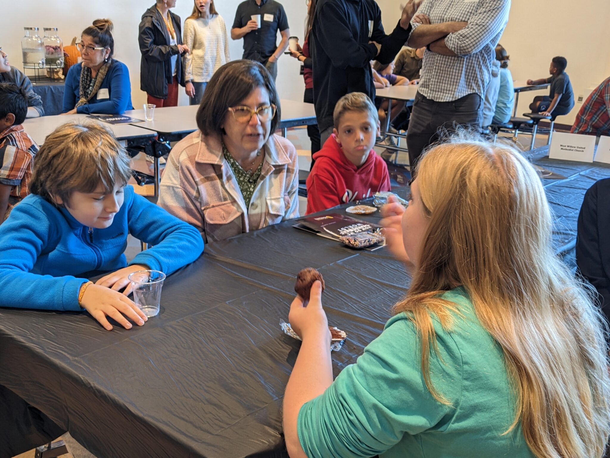 Students with Pastor in cafeteria.