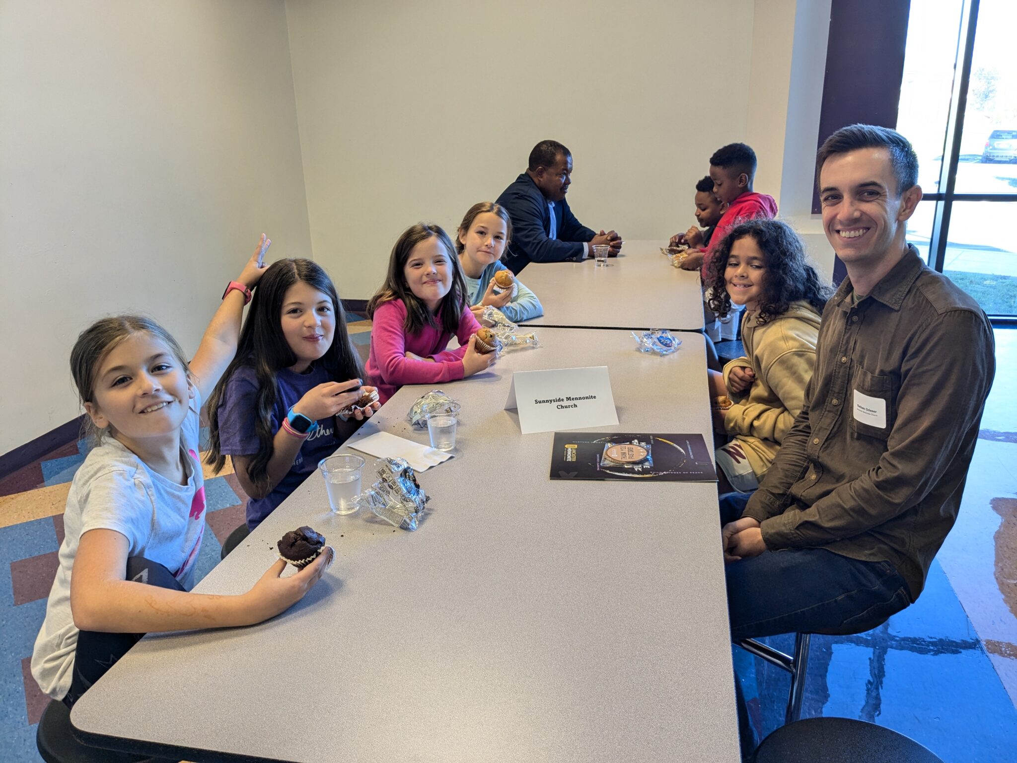 Students with Pastor in cafeteria.