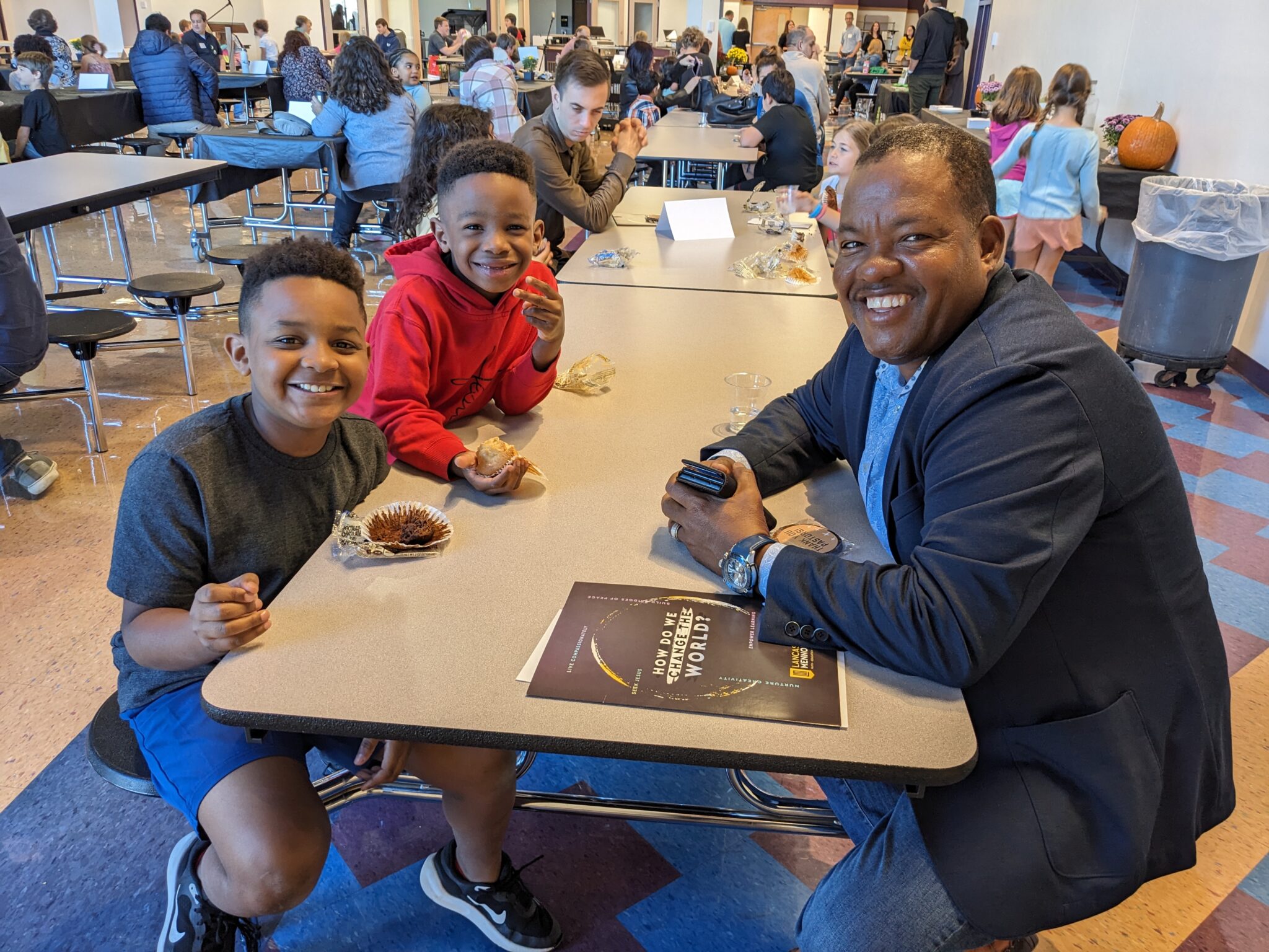 Students with Pastor in cafeteria.