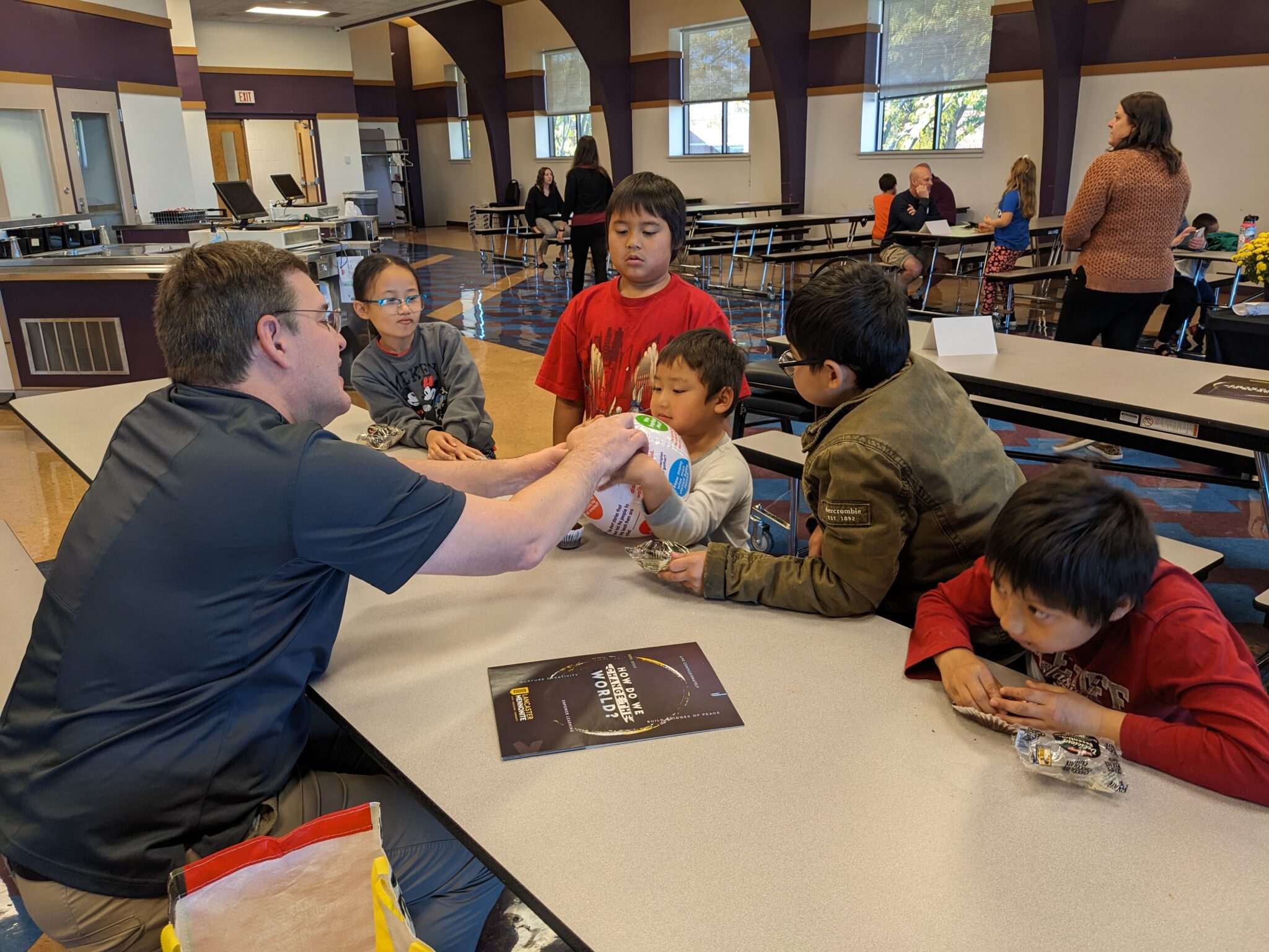 Students with Pastor in cafeteria.