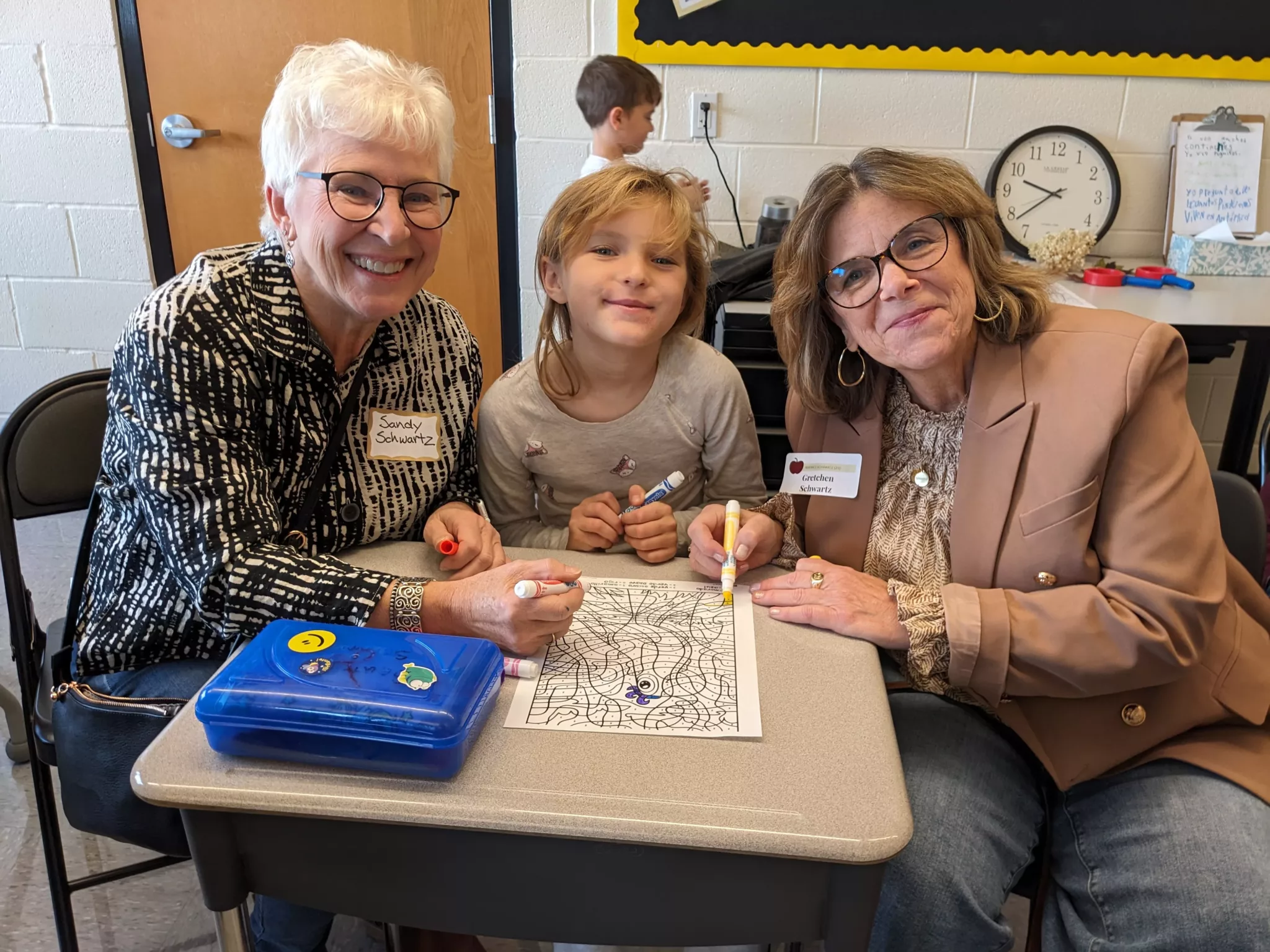 Student with grandparents at Grandparents Day coloring