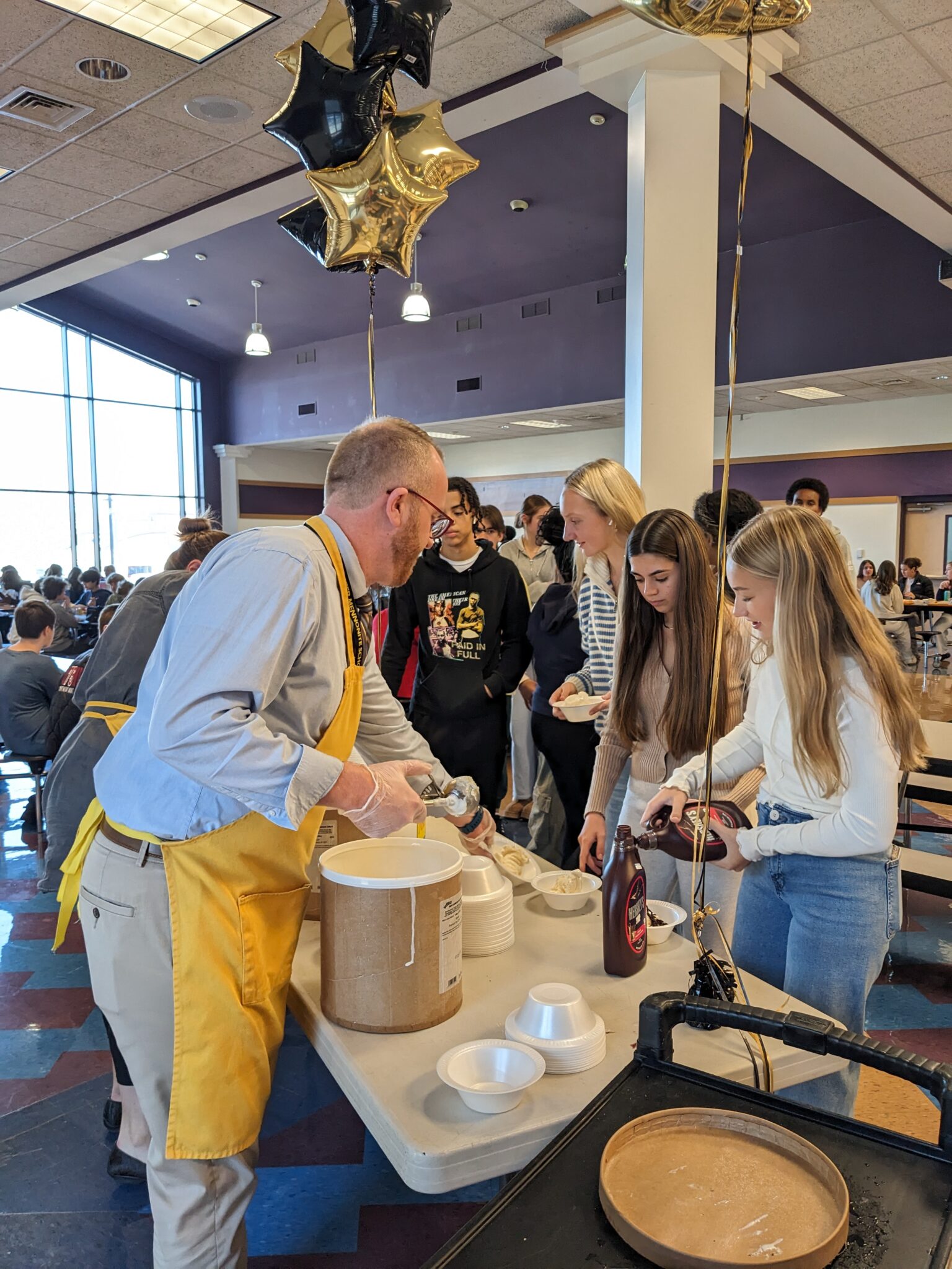 Mr. Benner serving ice cream to students