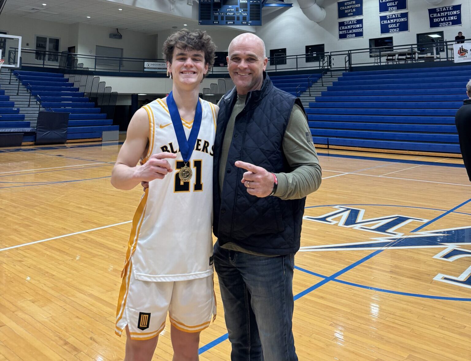 Chase Hurst '26 and Chad Hurst '91 basketball players and father son on the court after LL League final championship win
